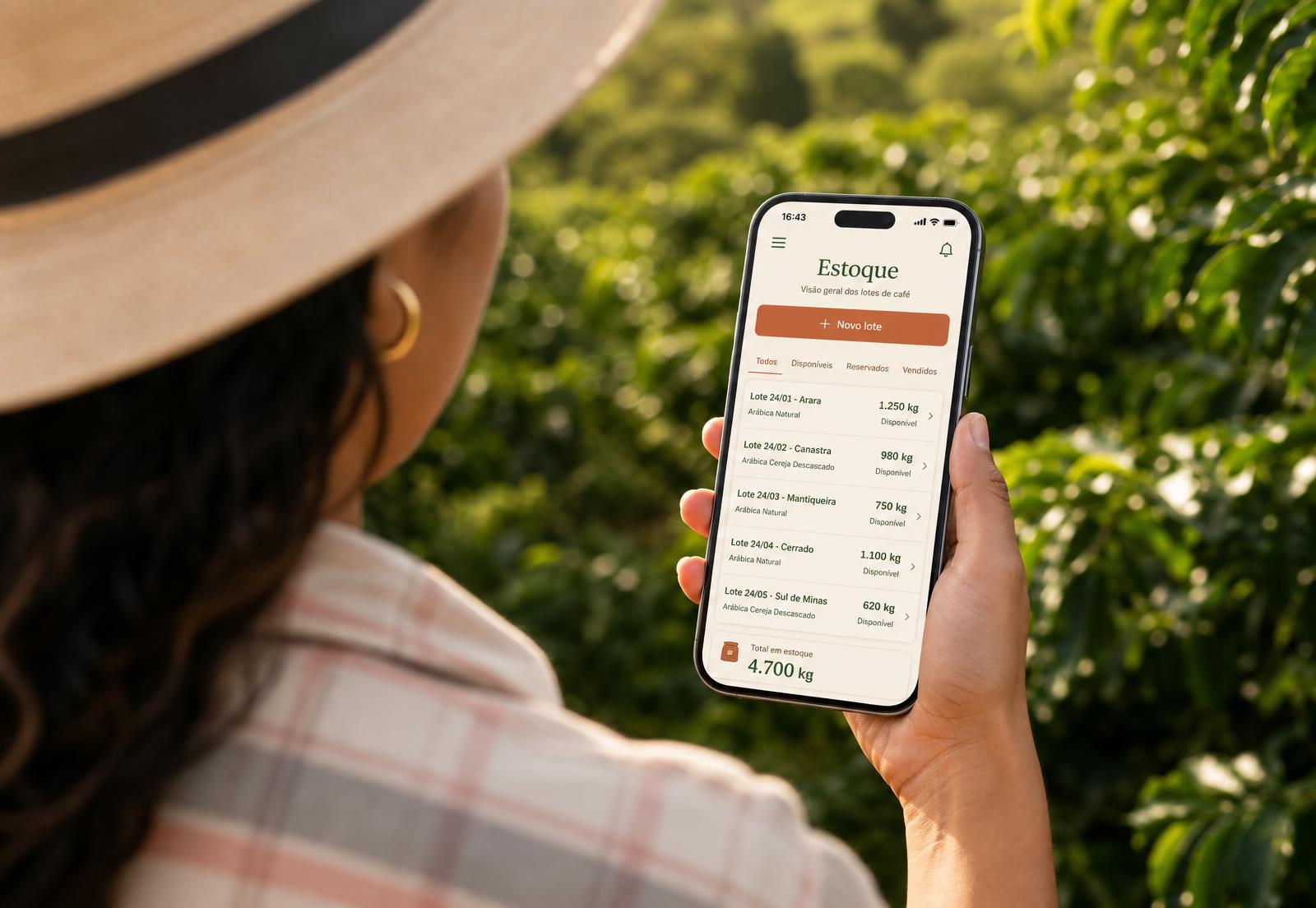 Produtora de café conferindo seu catálogo no celular na lavoura